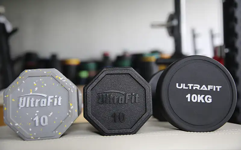 Three dumbbells of different sizes side by side with readable weight markings for choosing the right dumbbell weight