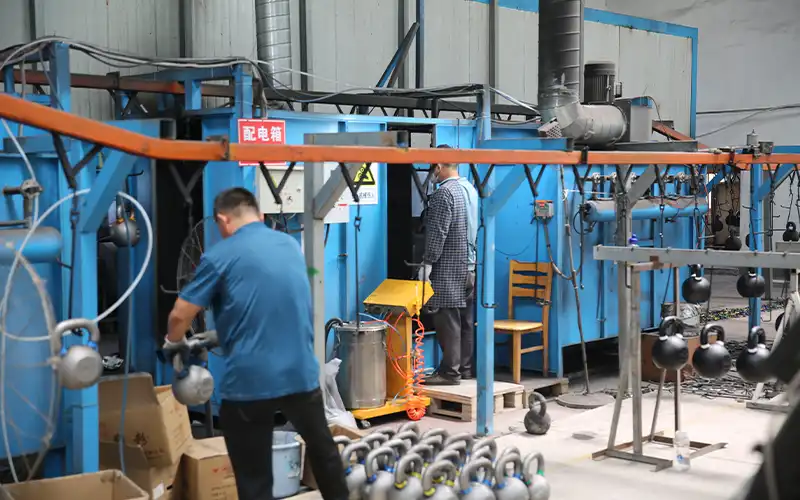 Kettlebell finishing and production line showing surface treatment at the factory