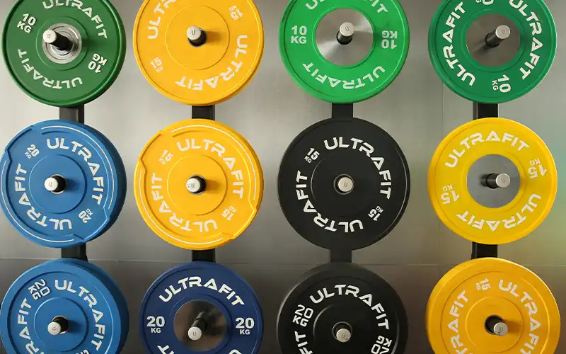 Assorted rubber-coated weight plates for home gym, showing different sizes and weights